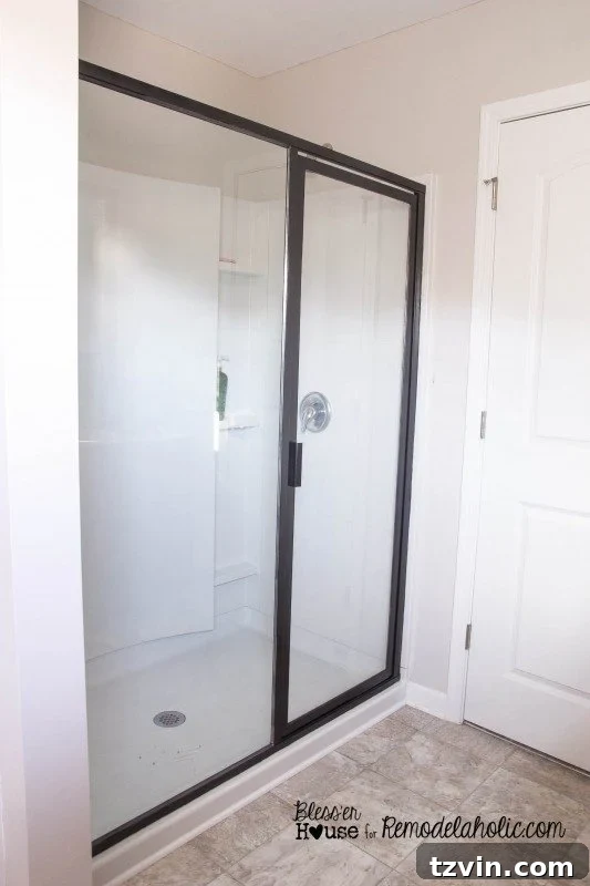 The newly painted shower door frame, transformed with hammered black spray paint, ready for the industrial grid application.
