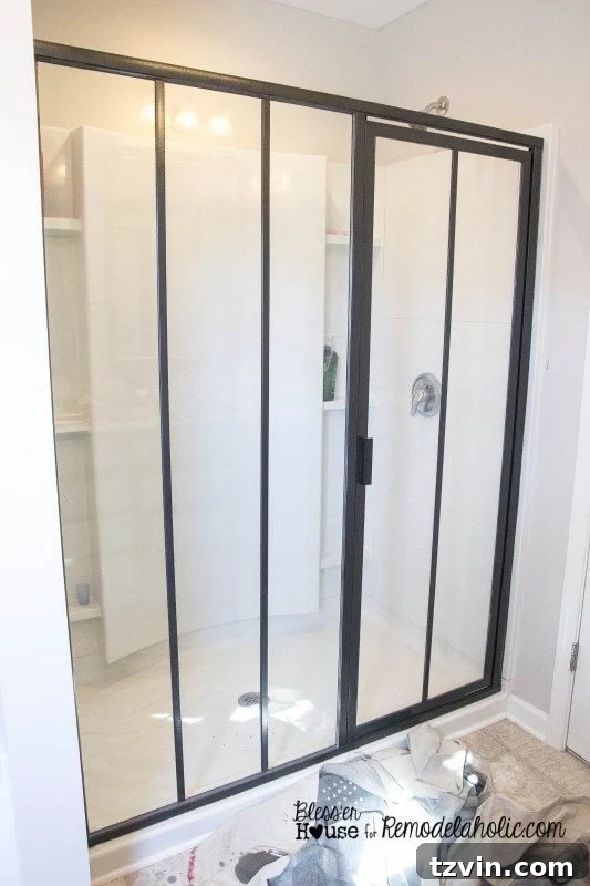 Carefully attaching a vertical polystyrene moulding strip to the shower glass, using a level to ensure perfect alignment.