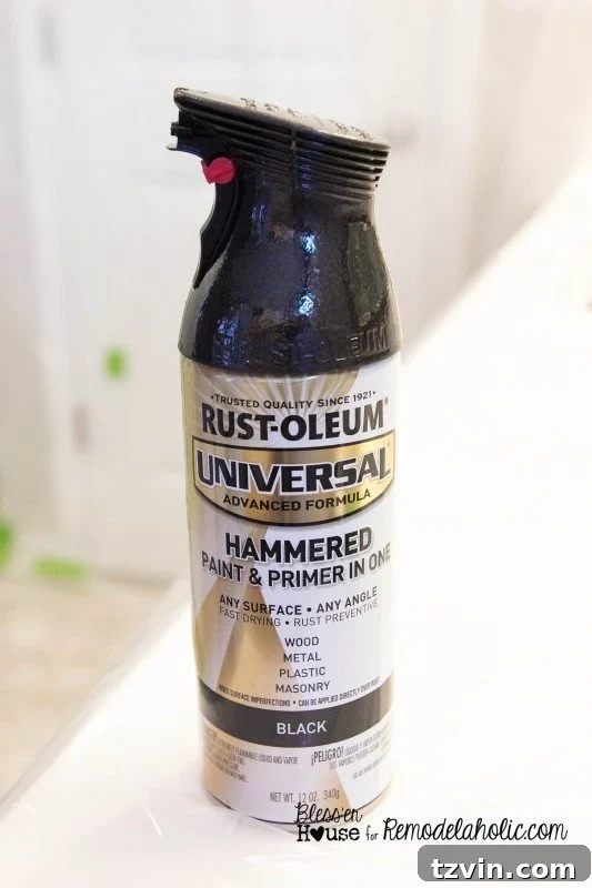 Applying the first coat of hammered black spray paint to the shower door frame for an industrial factory window look.