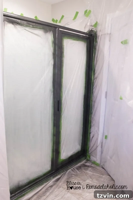 The shower door frame after three coats of hammered black spray paint, demonstrating a smooth and industrial finish.
