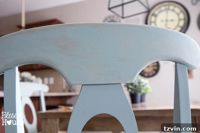 Close-up of a distressed duck egg blue dining chair, showing the beautiful effect of sanding through the paint to reveal the underlying wood.