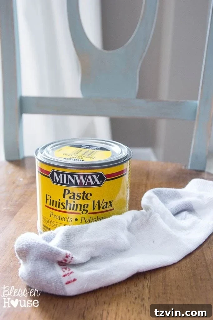 Applying Minwax Clear Paste Finishing Wax to a distressed dining chair using an old sock for a smooth, protective finish.