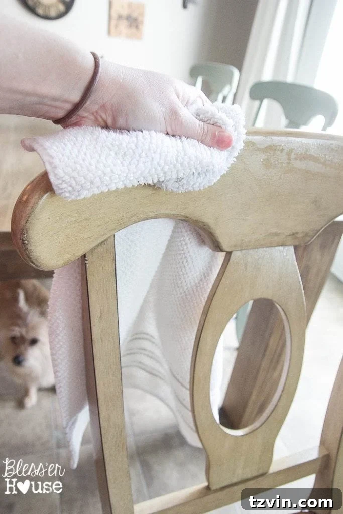 Dining chair being prepped for chalk paint with a quick wipe-down, showcasing a clean surface ready for transformation.