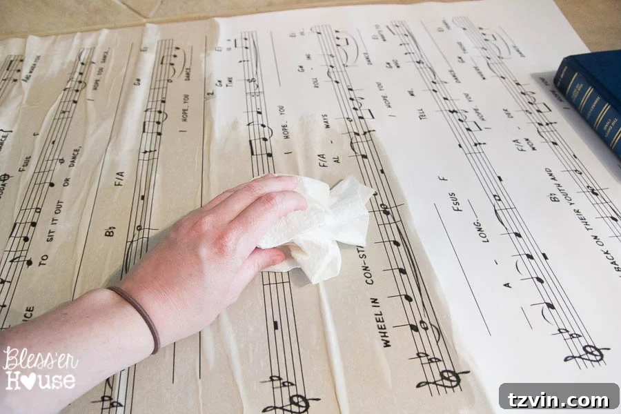 DIY Giant Sheet Music Wall Art 19 Blotting excess tea from the print with paper towels to control the antiquing effect.