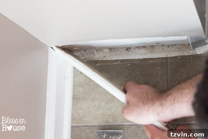 The baseboard slowly separating from the wall, showcasing the successful, damage-free removal process.