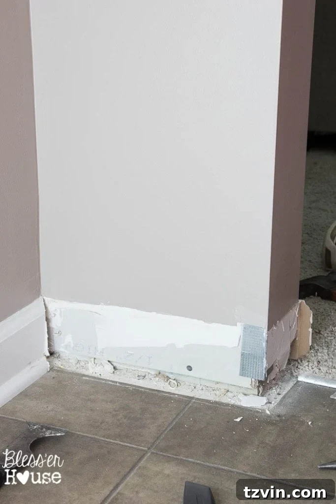 A section of wall after baseboard removal, showing minimal damage to the drywall, indicating a successful DIY project.