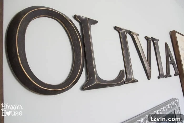 Our Prima Ballerina's Dream Bedroom Transformation 31 Letters spelling 'OLIVIA' on the ballet barre wall between sheet music art