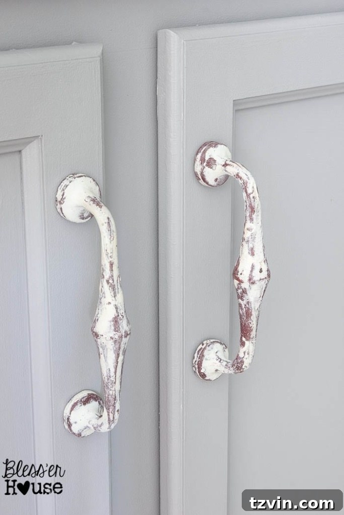 Newly painted white cabinet with stylish decorative handles and unique spigot-looking knobs