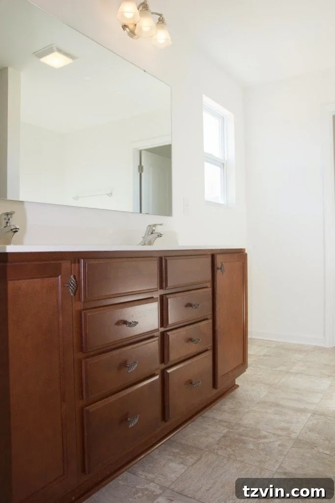 Before image of a bathroom vanity with outdated cherry wood cabinets