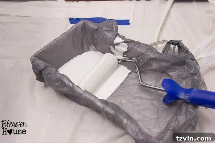 Pouring primer into a paint tray that has been lined with a plastic bag for quick and easy cleanup