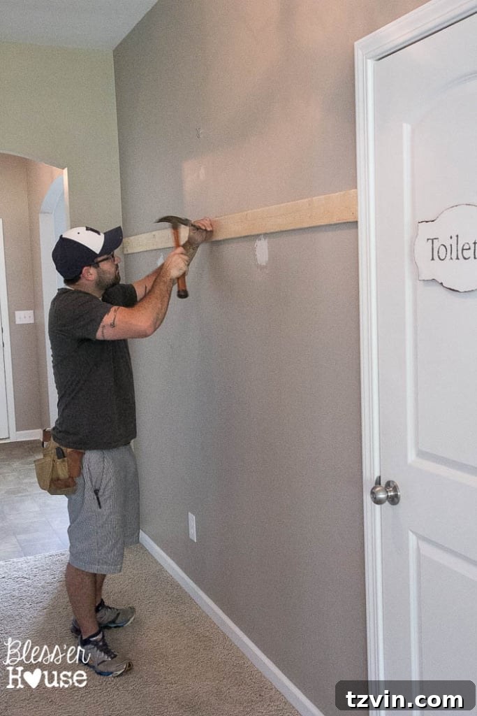 Nailing board to wall to start board and batten