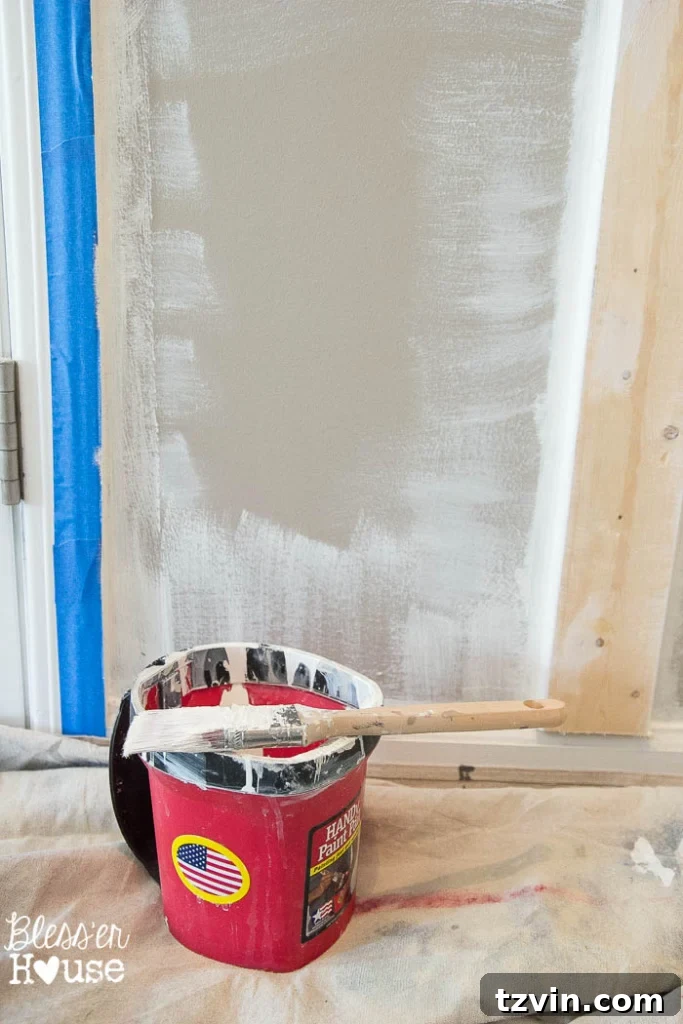 Applying Glidden paint to the trim of the board and batten.