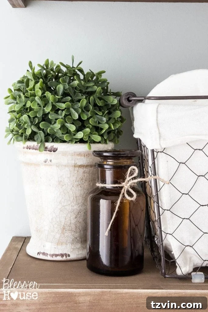 Close-up of the rustic floating shelves, featuring a repurposed Halloween apothecary bottle, a chicken wire basket, and various charming farmhouse decor items.