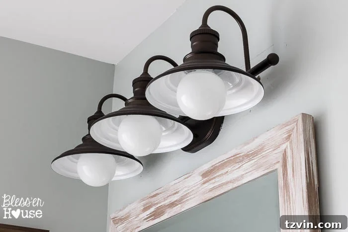 Elegant Allen + Roth Hainsbrook vanity light casting a warm glow, a significant upgrade for the modern farmhouse bathroom.