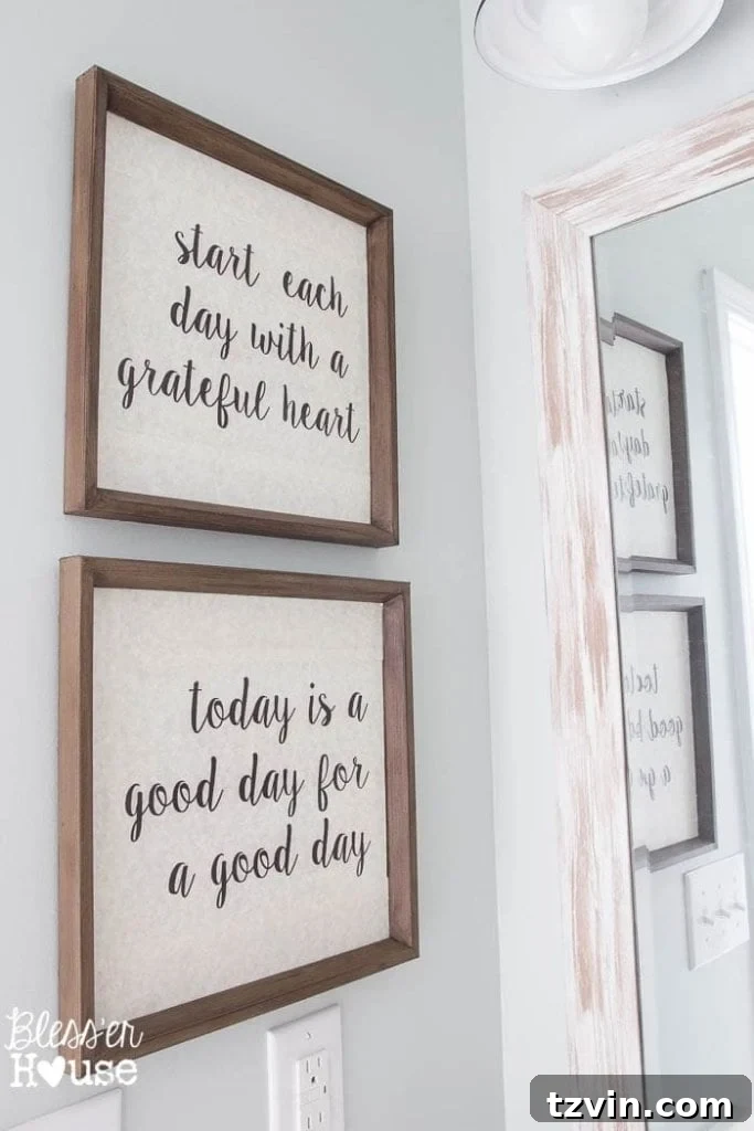 Custom DIY typography art, repurposed from thrift store finds, adorning the walls of the modern farmhouse bathroom.