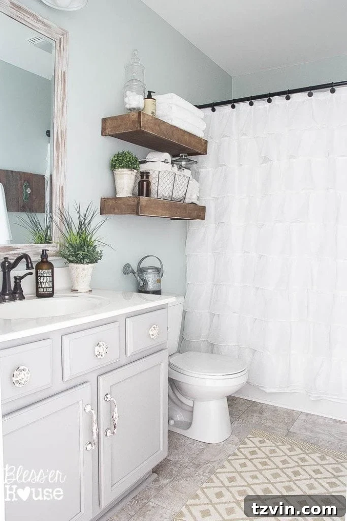 Modern Farmhouse Bathroom Makeover Reveal: The renovated bathroom featuring a ruffled shower curtain, rustic wooden elements, and fresh white towels.