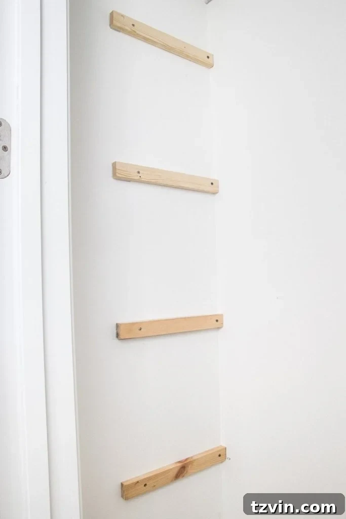 Installing 1x2 furring strips as side supports for DIY closet shelves, demonstrating the use of a level and screws for secure attachment.