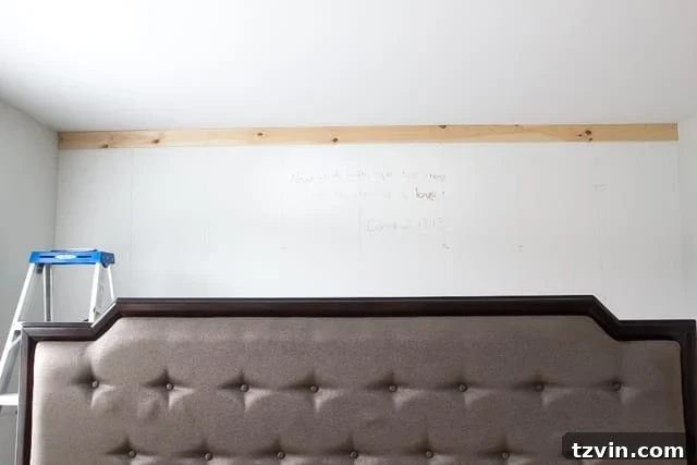 Husband writing Bible verse on wall before DIY paneling