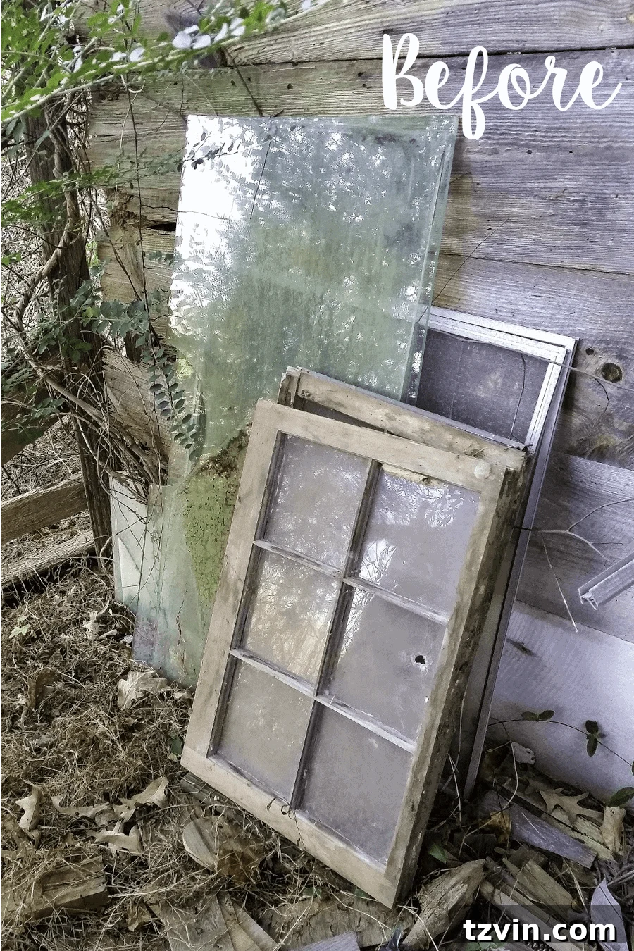 A single old, rustic window frame leaning against a wall, showing signs of age and neglect, hinting at its potential for an upcycled project.