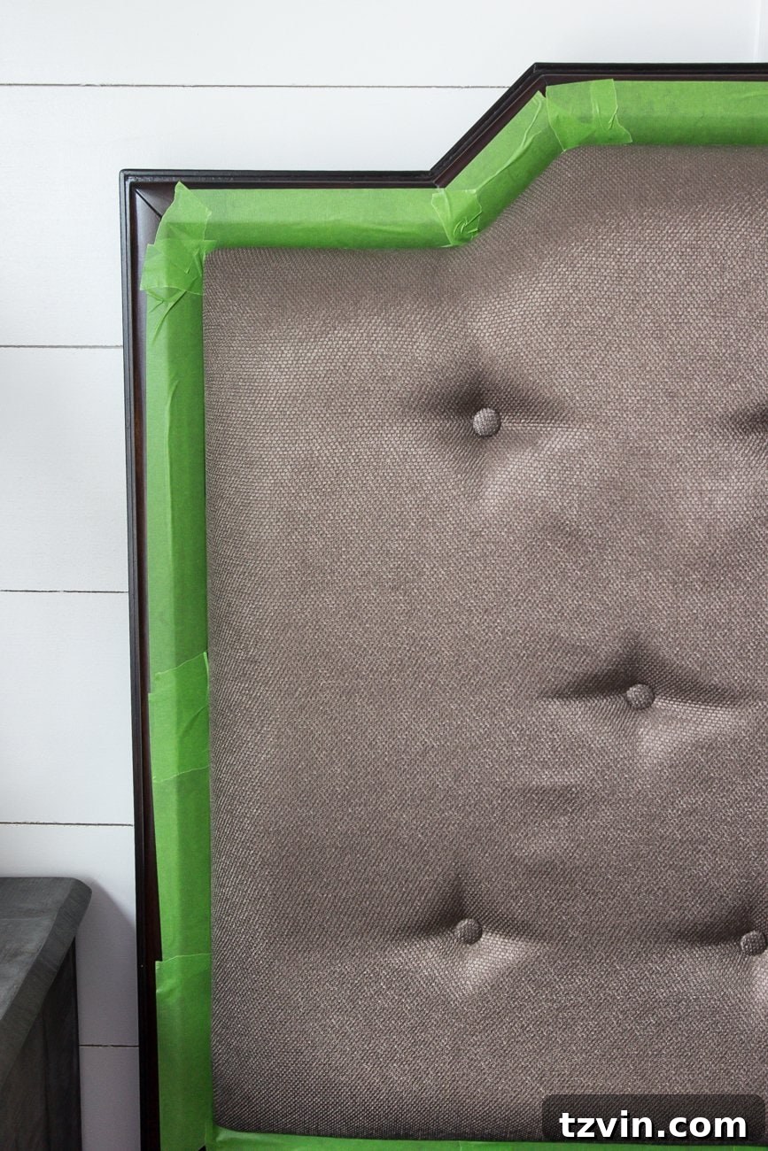 Revitalize Your Sofa: Easy Upholstery Painting 4 Applying painter's tape to protect wood trim on upholstered headboard