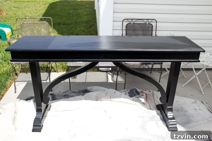 Before: A shiny black table awaiting a weathered wood transformation with paint and wax