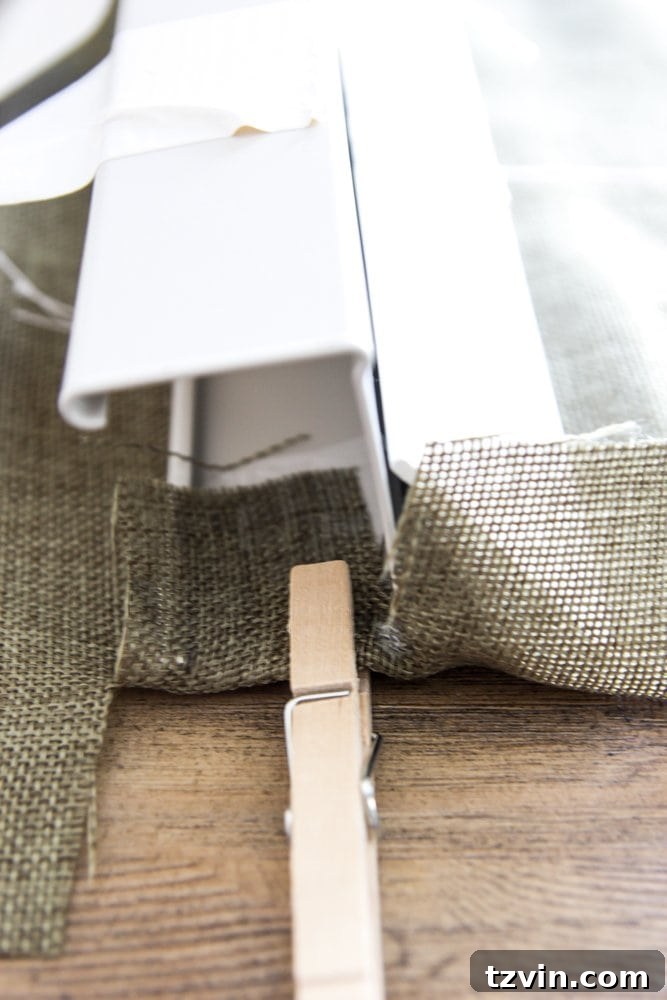 Hot gluing fabric to the inside of the blind header, clamped with a clothespin