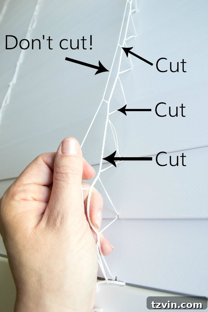 Close-up showing which strings to cut and which to keep on the blinds for DIY Roman shades