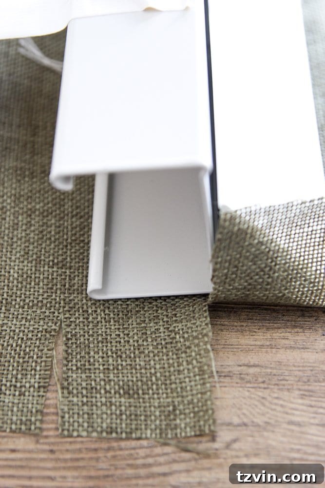 Fabric tab cut and secured with hot glue to the top blind header for Roman shades