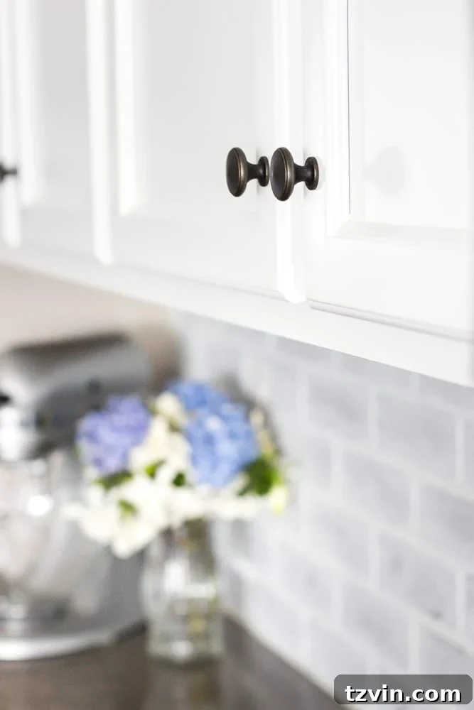 Elevate Your Kitchen: Pro Strategies for Cabinet Painting 17 A wider shot showcasing the bright, modern kitchen with freshly painted white cabinets, new countertops, and a glimpse of the whitewashed brick backsplash, waiting for a new stainless steel range.