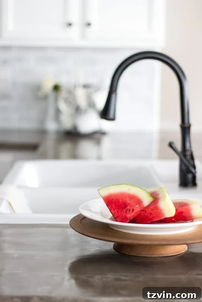 Elevate Your Kitchen: Pro Strategies for Cabinet Painting 20 View of the newly installed IKEA farmhouse sink and faucet against the DIY concrete countertops and white painted cabinets, showcasing a cohesive kitchen design.