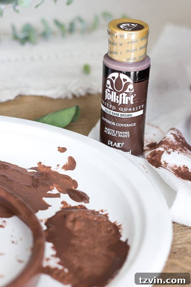 Rustic Chic Vintage Scale Makeover 6 Dabbing bark brown acrylic paint onto the copper-sprayed scale to create the initial layer of faux rust texture. Learn this crucial step for dimension.
