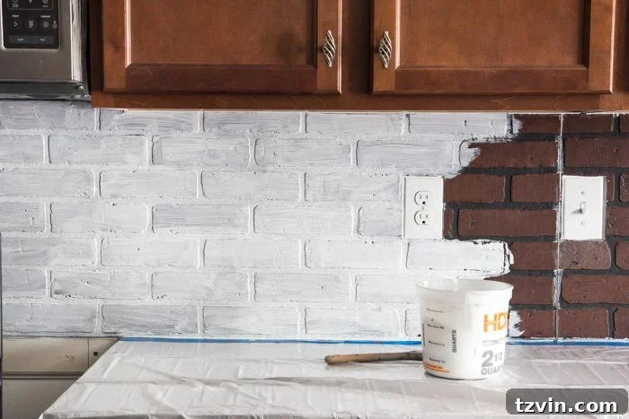 Applying the first coat of whitewash to faux brick paneling for a distressed kitchen backsplash