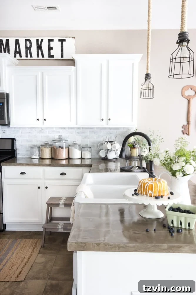 Modern farmhouse kitchen featuring a DIY whitewashed faux brick backsplash, white cabinets, and concrete countertops