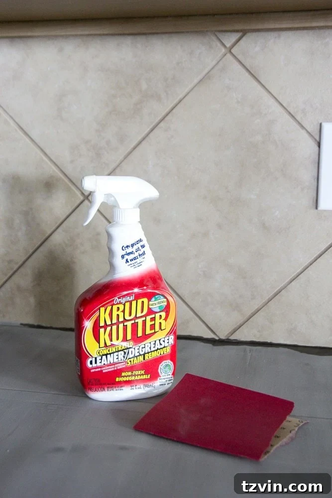 Thoroughly degreasing an existing tile backsplash for optimal adhesion of faux brick panels