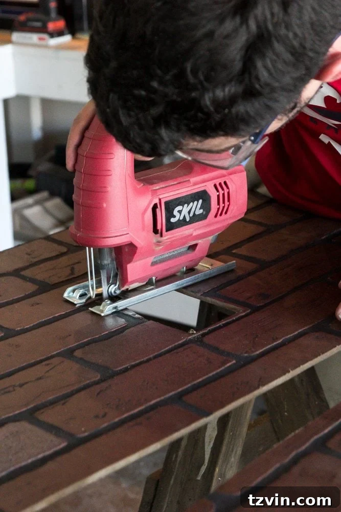 Using a jigsaw to cut precise outlet holes in faux brick paneling for a kitchen backsplash