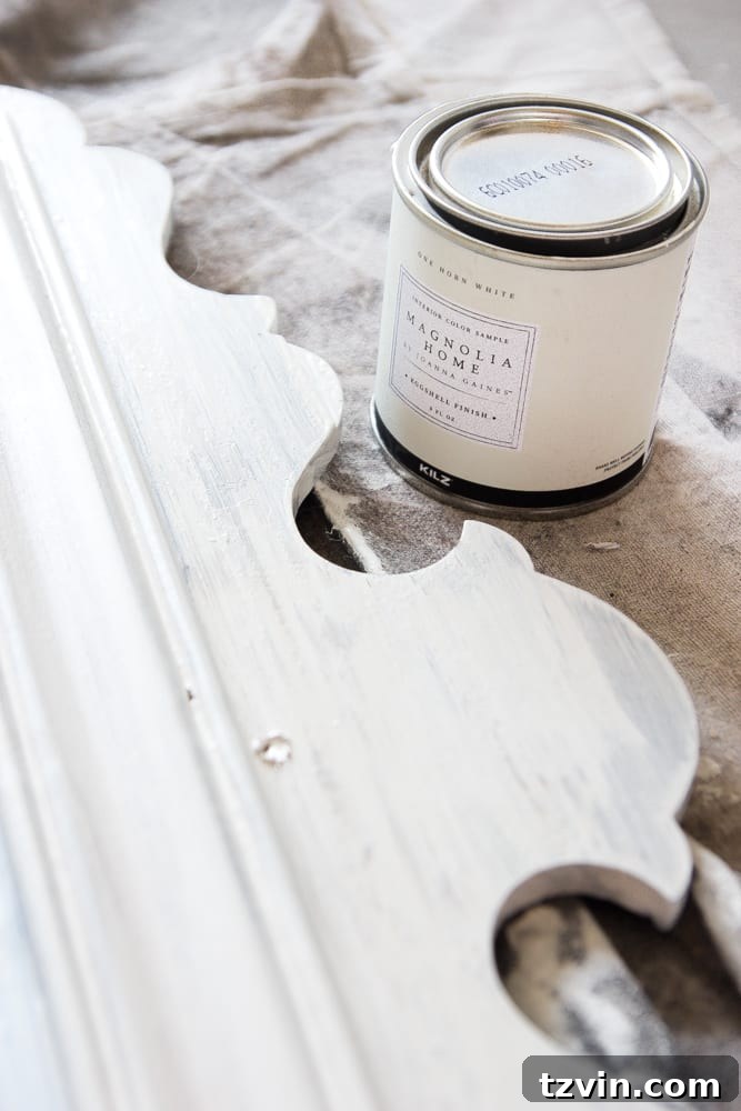 Mirror Frames Reimagined as Photo Displays 6 Detail shot of a vintage frame being painted with Magnolia Home Paint, showing the brush strokes characteristic of its interior finish.