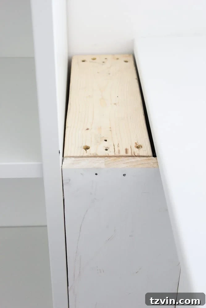 Building a box to fill a gap between an IKEA bookcase and a half wall, a crucial step in creating built-in shelves.