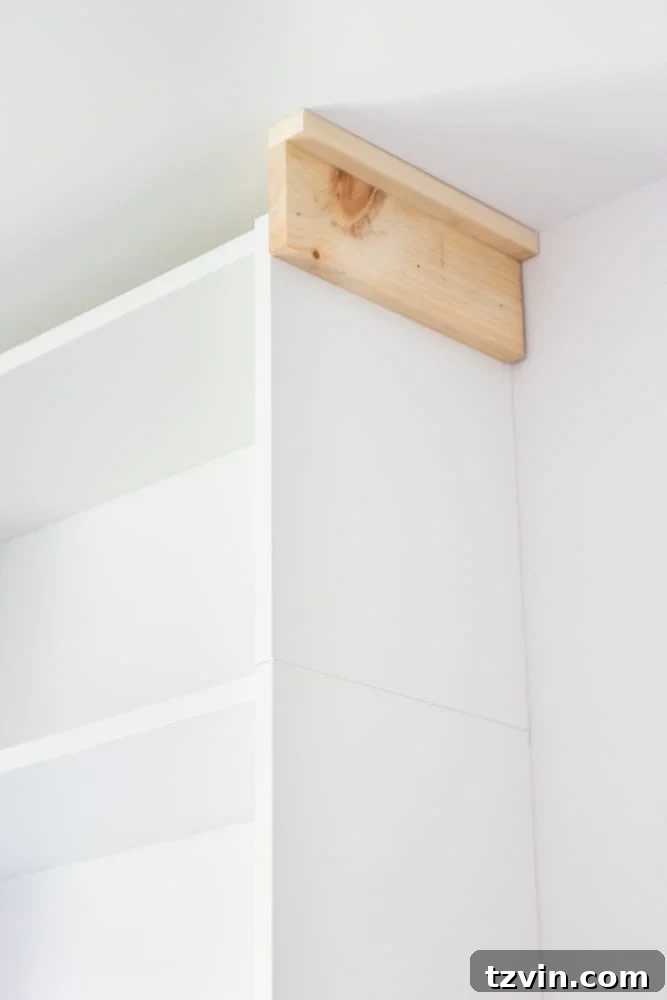 Craftsman-style header installed on top of IKEA bookcases, seamlessly covering the ceiling gap for a custom built-in effect.
