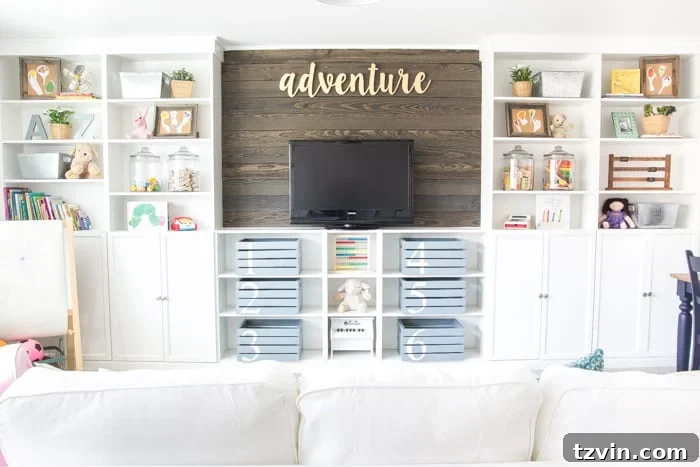 Completed DIY built-in bookshelves with a wood plank wall in a vibrant playroom, offering extensive storage.
