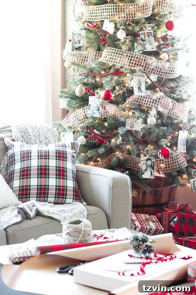 Decorated Christmas tree in a rustic barrel planter with burlap ribbon and wooden cranberry garland.