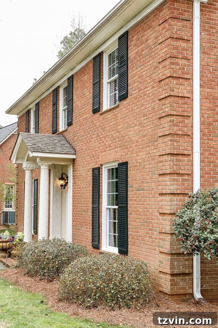Unveiling Our New Home 4 A closer view of the brick Colonial's entrance, showing intricate details and a welcoming porch.