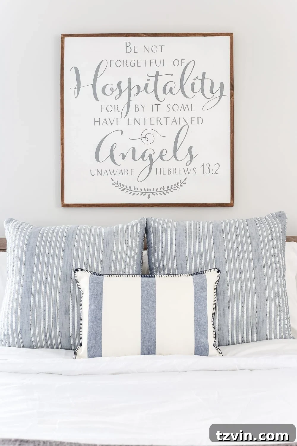 Hospitality sign above bed in blue guest room