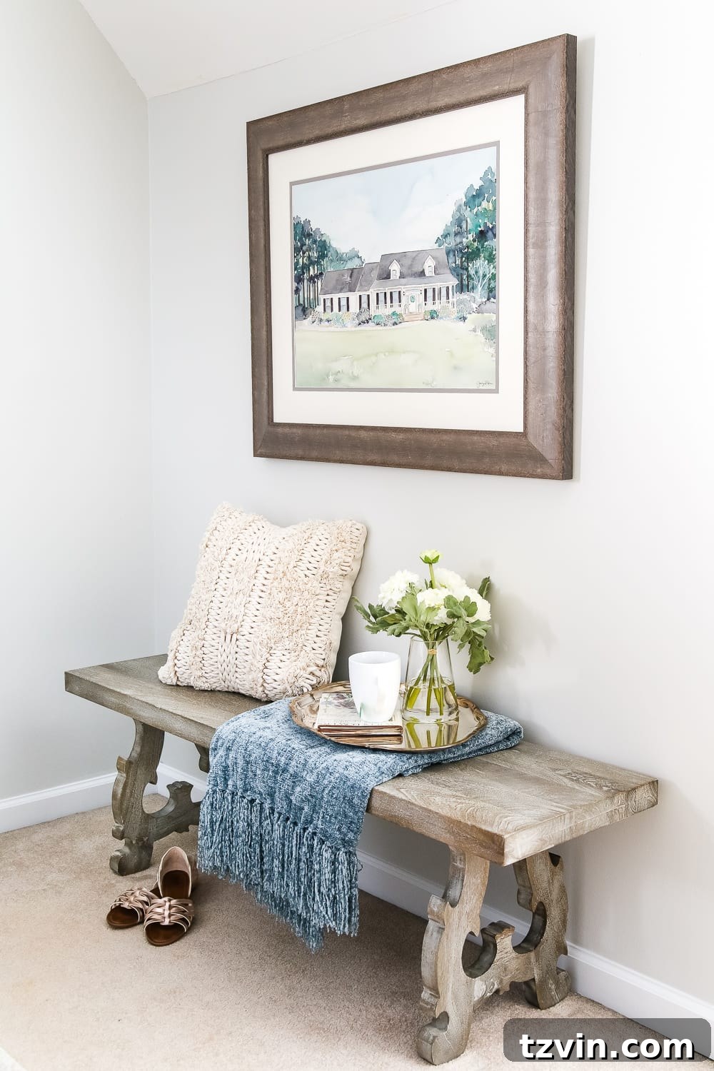 Guest bedroom with bench for luggage and custom home portrait