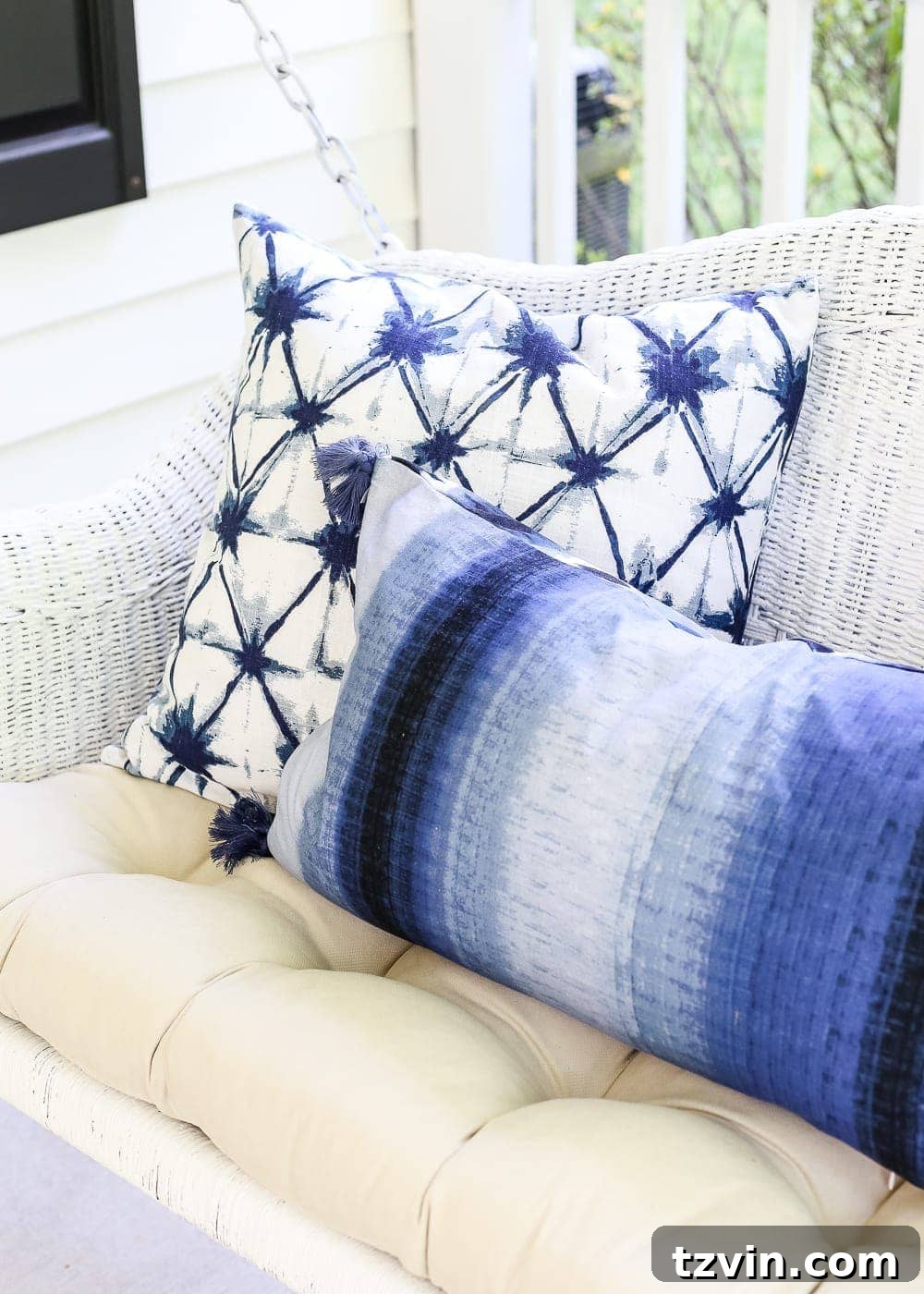 Unlock Your Outdoor Space's Full Potential 12 A styled outdoor porch corner with white rocking chairs, a garden stool, and a variety of colorful throw pillows.
