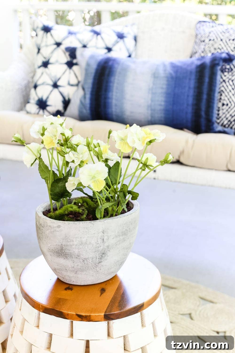 Unlock Your Outdoor Space's Full Potential 13 A neatly decorated outdoor porch with white rocking chairs, blue accents, and a garden stool as a side table.