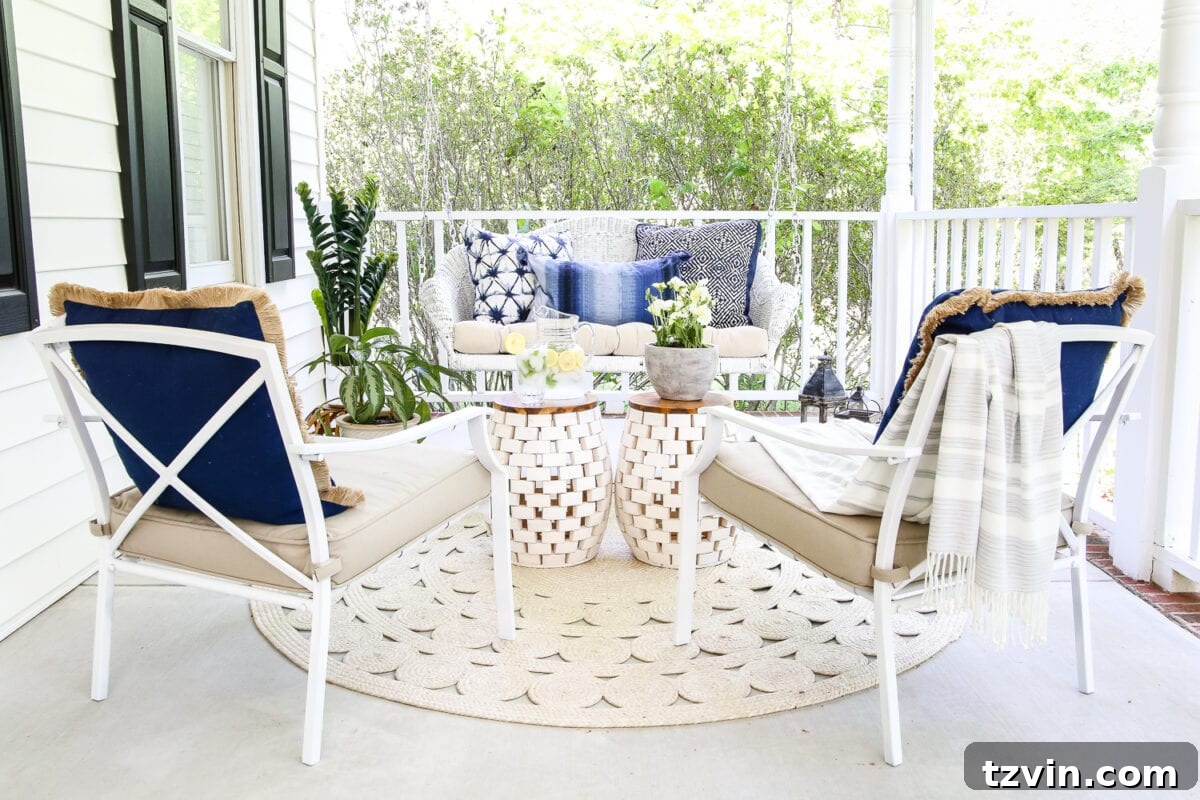 Unlock Your Outdoor Space's Full Potential 14 Wide shot of a beautifully decorated large outdoor porch with white rocking chairs, blue pillows, and a wooden garden stool.