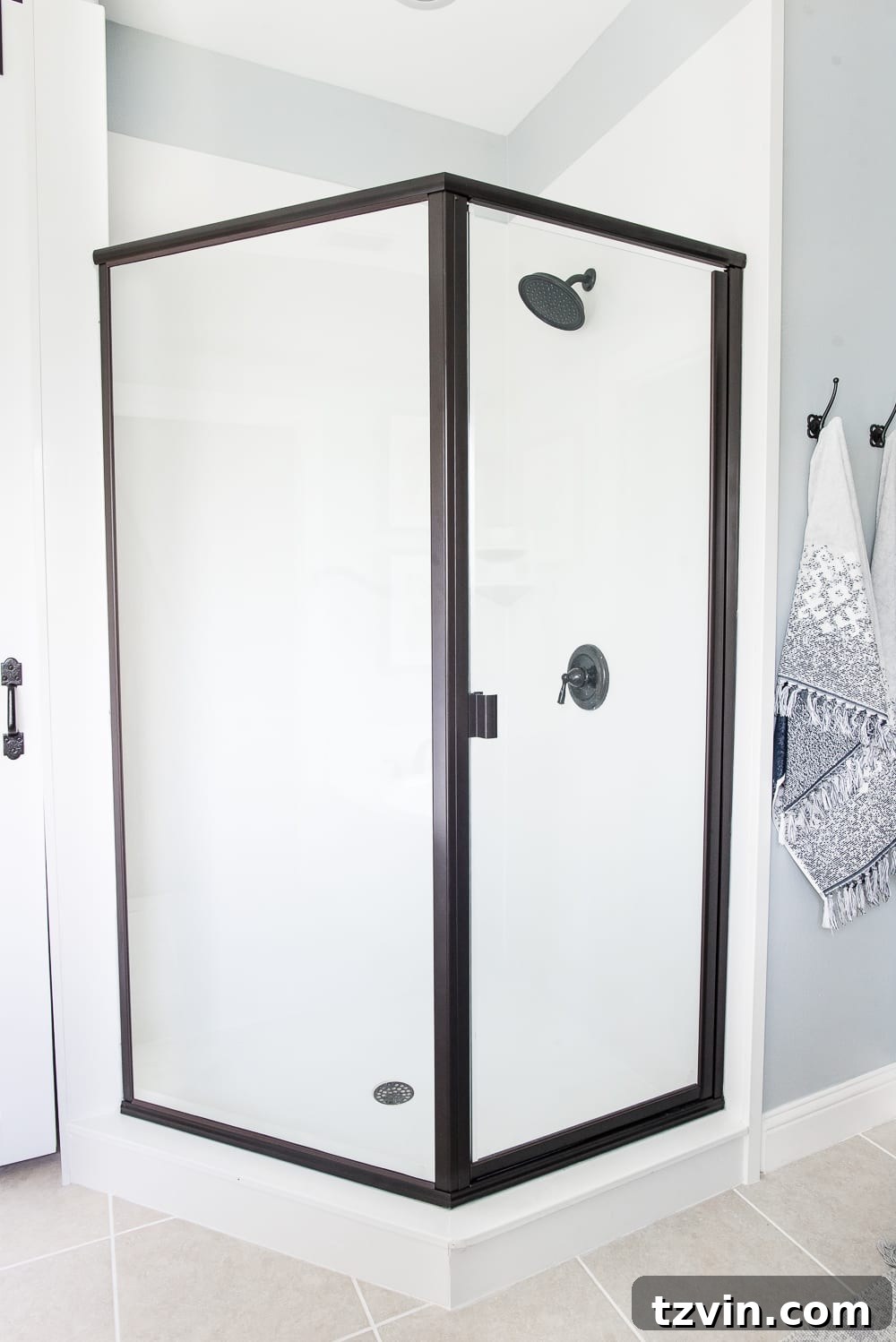 Lowes Bathroom Remodel Showcase 16 A new, clear glass shower door with oil-rubbed bronze framing enhances the bathroom's modern farmhouse style.