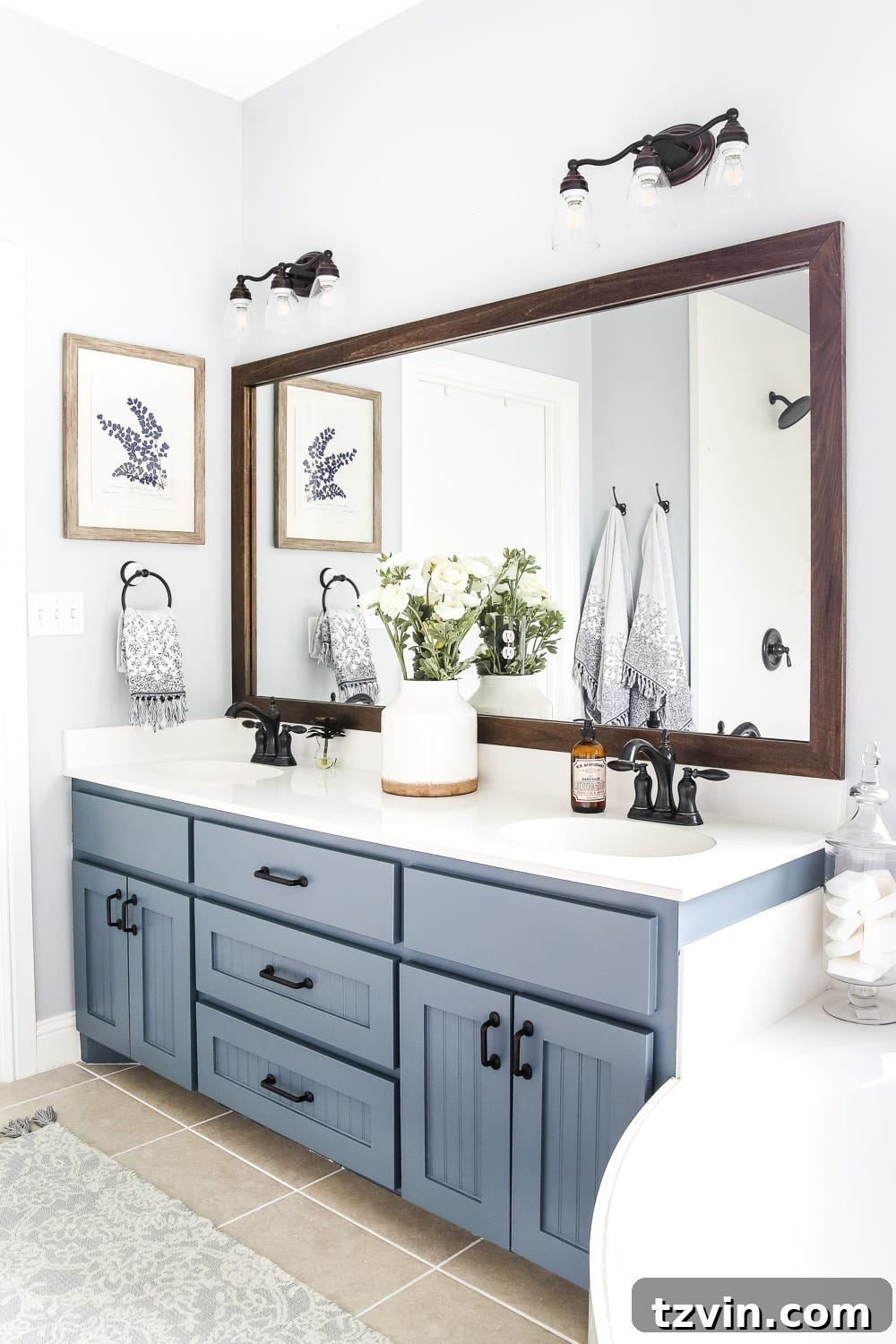 Lowes Bathroom Remodel Showcase 23 The framed builder-grade mirror and freshly painted grout lines contribute to the bathroom's rustic charm.