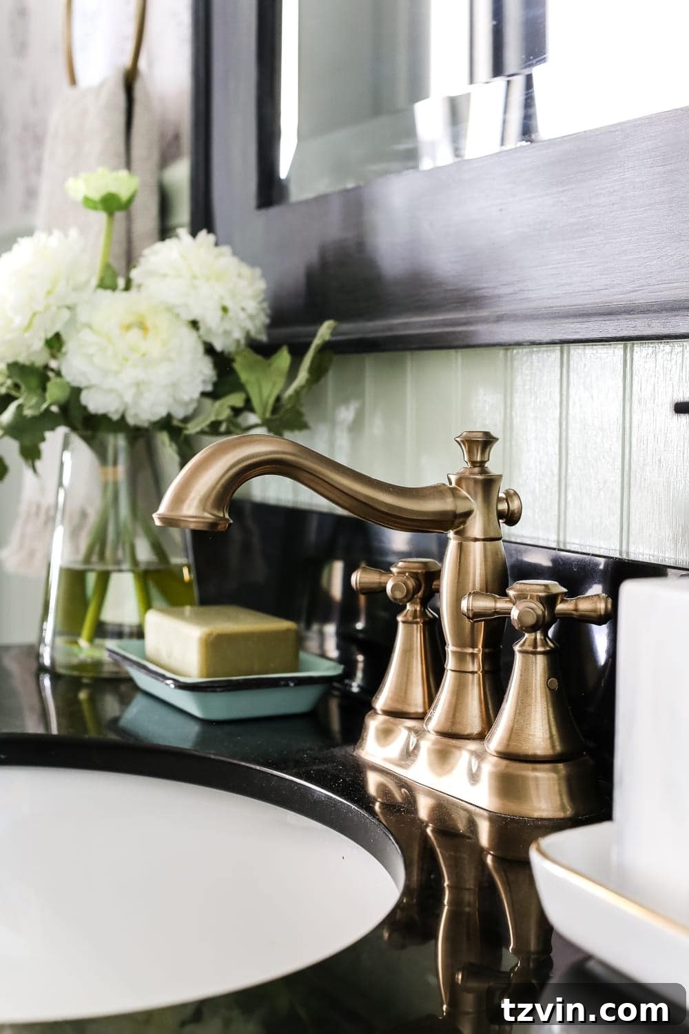 Delta Faucet Cassidy in Champagne Bronze | blesserhouse.com - A dated powder room gets a modern meets traditional, urban meets farmhouse makeover with aquas, black and white, and antique brass. 