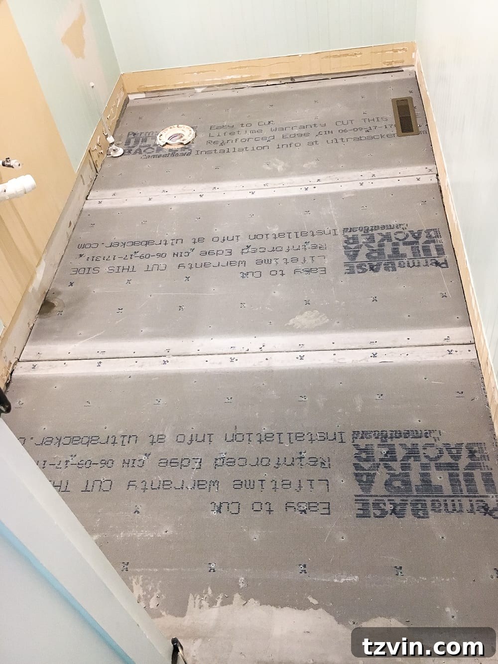 Powder Room Radiance: Faux Marble Tile Floor Upgrade 6 Close-up of the subfloor being prepped by the contractor, showcasing the work required to level the foundation before installing the new faux marble tile.